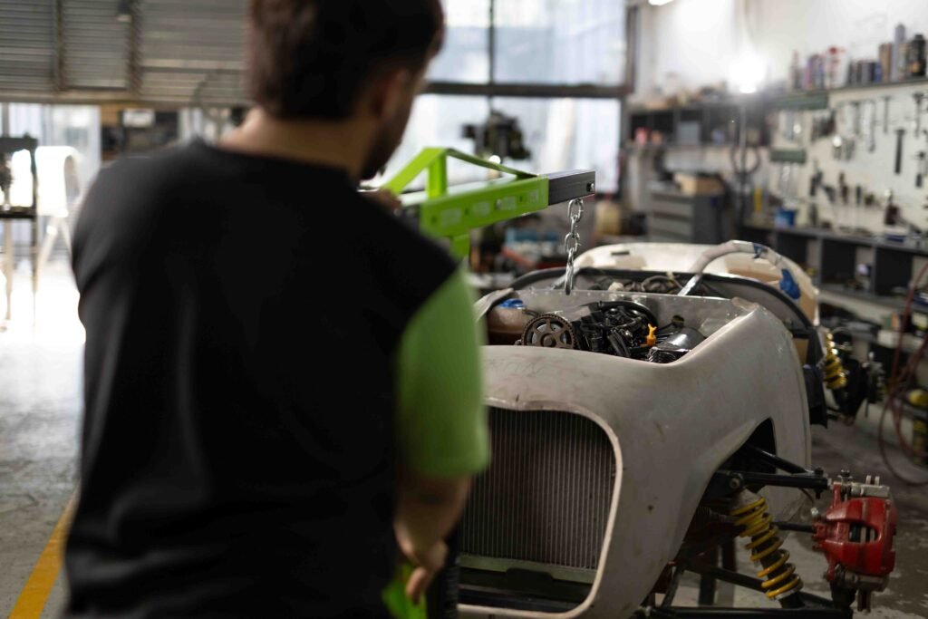 JMC36502-77 Mecánico interviniendo el motor de un auto en el taller durante la producción de Kroner
